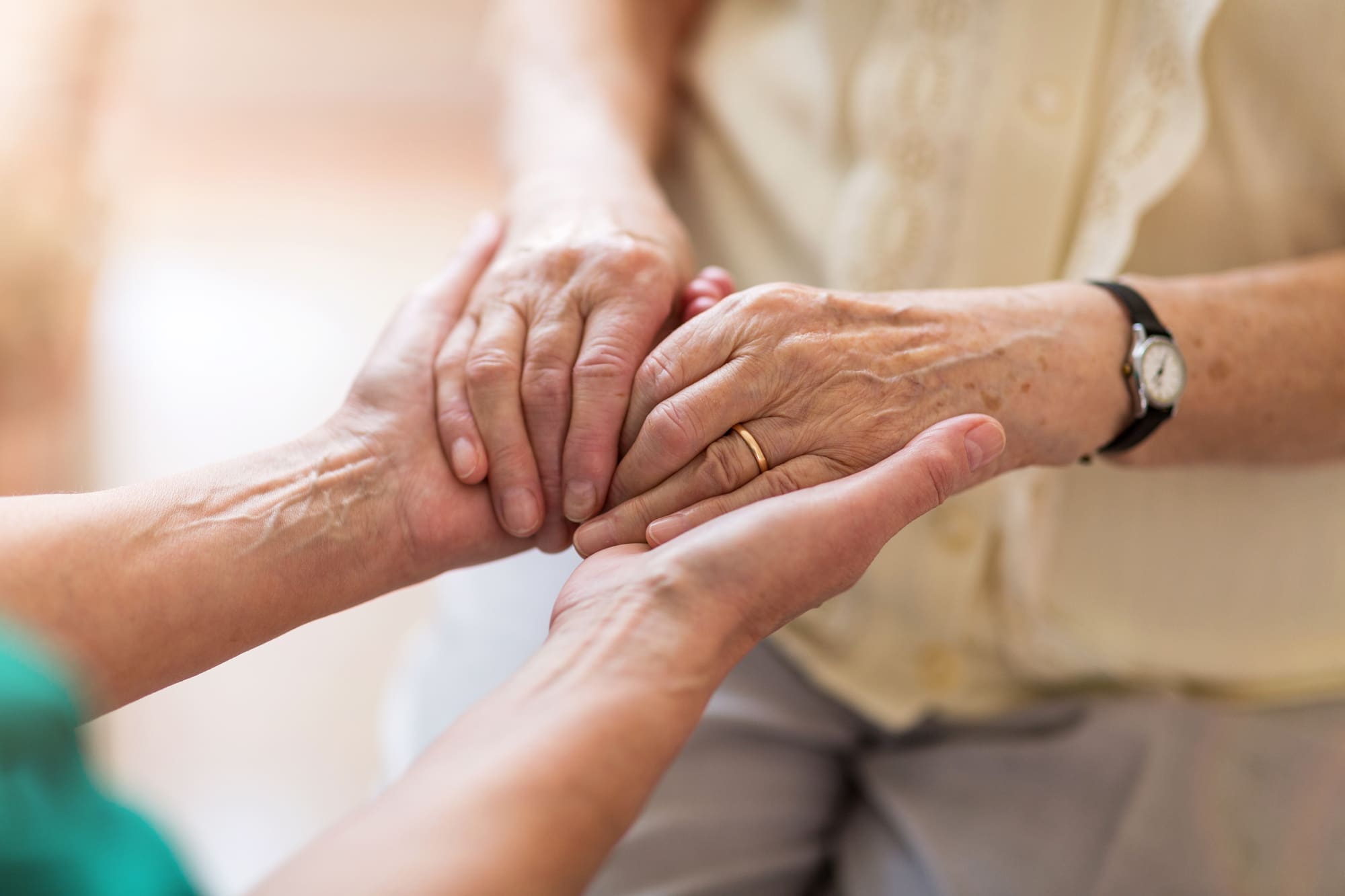 caregiver holding seniors hands
