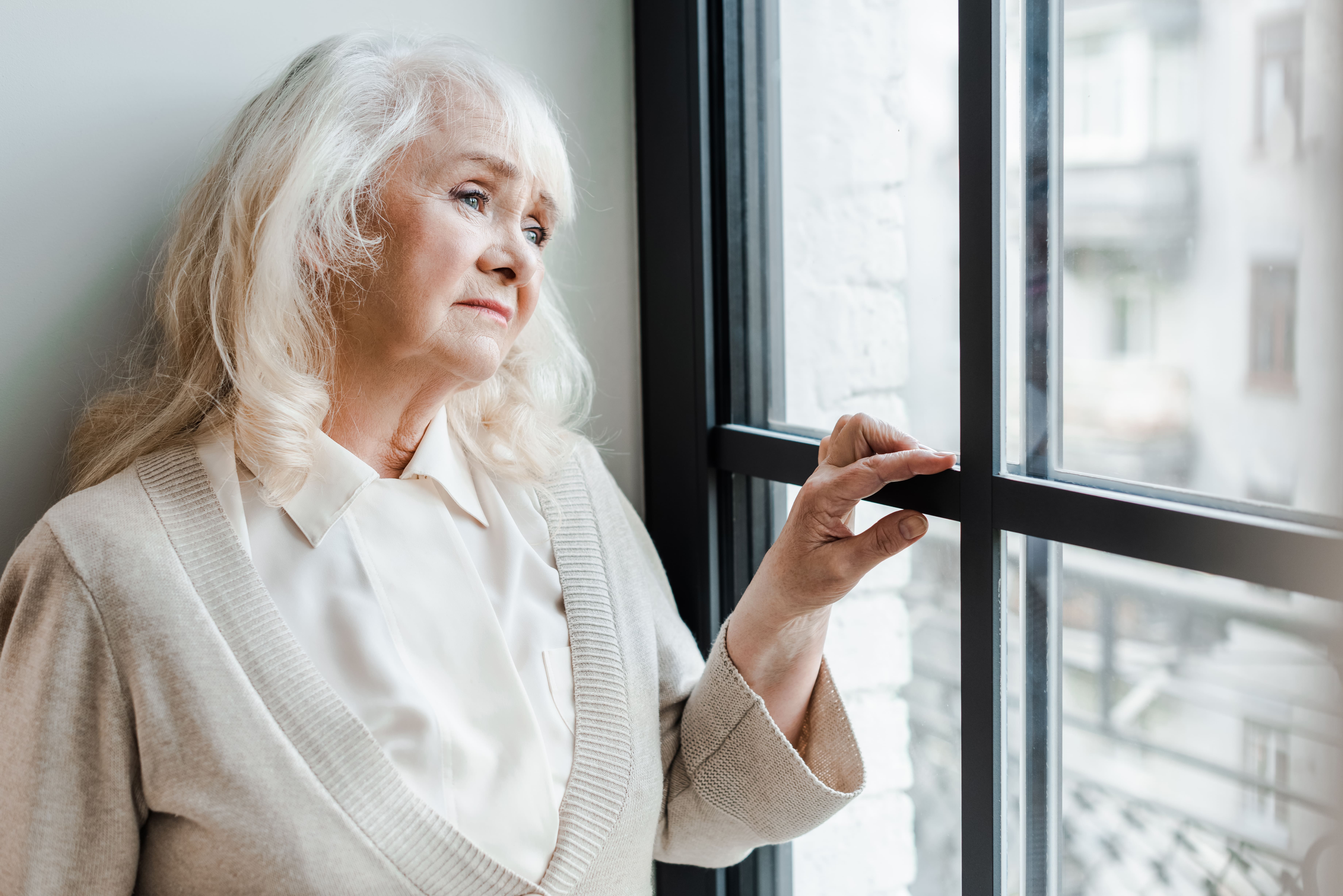 senior looking sadly out window, needs concierge program