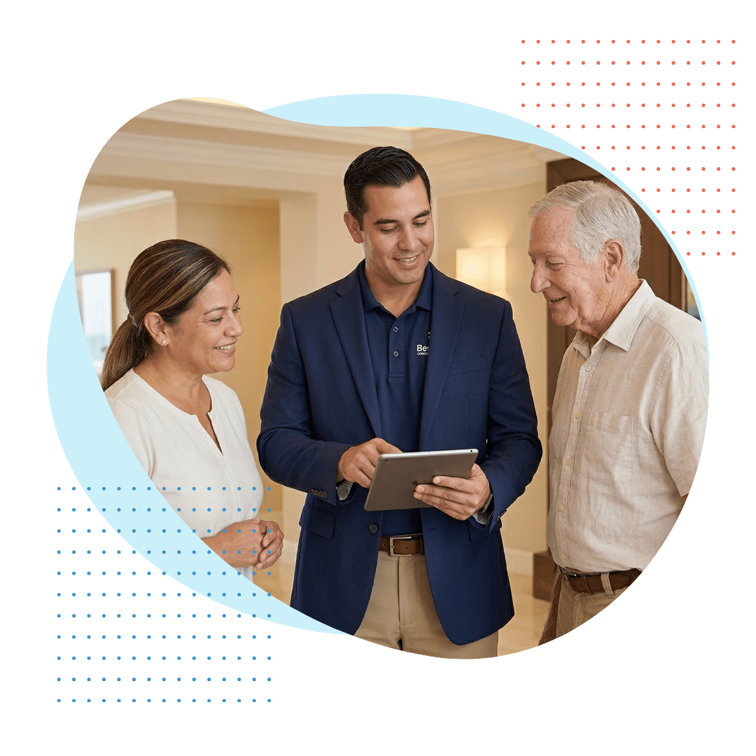A professional and knowledgeable male Best Care concierge care specialist, wearing a polished navy blazer over a polo shirt (branded), is presenting a customized wellness and activity plan on a tablet to a senior couple. The environment is warm and prestigious.